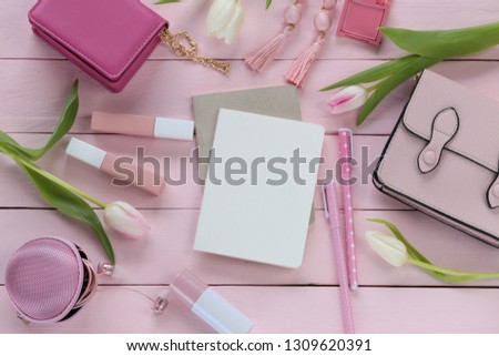 Spring  fashion Flat lay.Spring to-do list.International Women's Day. clutch, rose glasses, flowers tulips, bag, blank notebook,beige lipstick set on pink wooden background.top view, copy space
