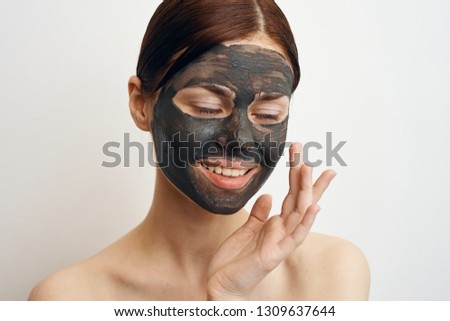 woman smiling with eyes closed on clay mask face