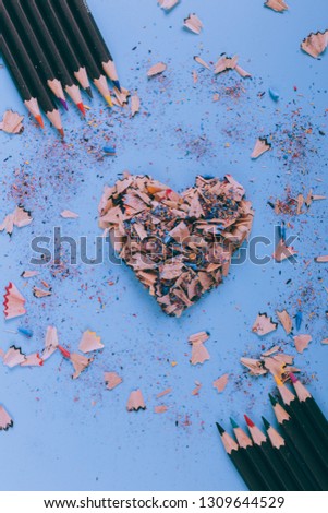 Abstract colorful background. Color pencils on a blue background. Valentines day abstract background. Card with hearts. Background pastel colors.  Flat lay, top view.