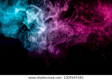 Abstract art colored  blue and pink smoke on black isolated background. Stop the movement of multicolored smoke on dark background
