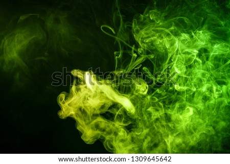 
Abstract art colored  green smoke on black isolated background. Stop the movement of multicolored smoke on dark background
