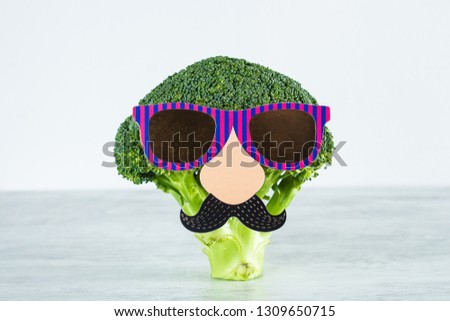 Funny cute vegetables broccoli. Broccoli with paper mustache and glasses. Healthy food concept