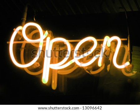 A neon orange OPEN sign glowing in the window of a restaurant.