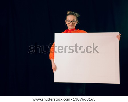 beautiful fashionable girl in red with a white poster on a black background.