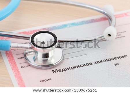 Medical certificate form. Getting or replacing a driver's license. Stethoscope lying on a medical document. Translation of the name from Russian to English as a medical report.