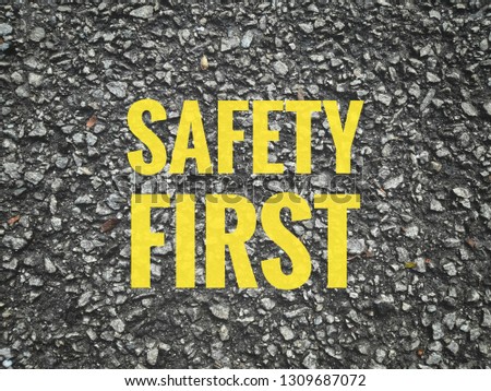 SAFETY FIRST written on the asphalt road background. Concept of vehicle safety