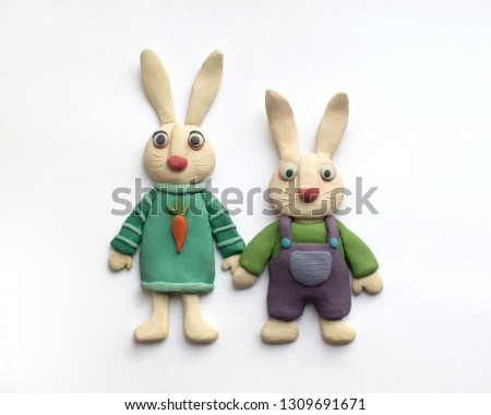 Plasticine rabbits in clothes holding hands. Cute illustration on white background Royalty-Free Stock Photo #1309691671