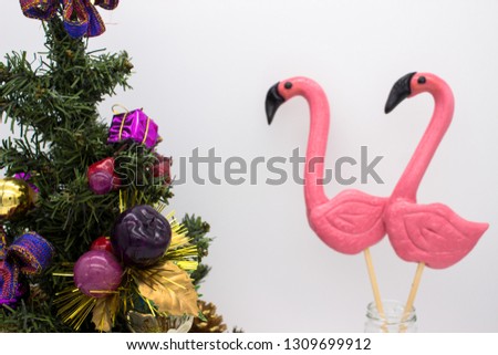 Two lollipops in the form beautiful flamingo and christmas tree with christmas ornaments