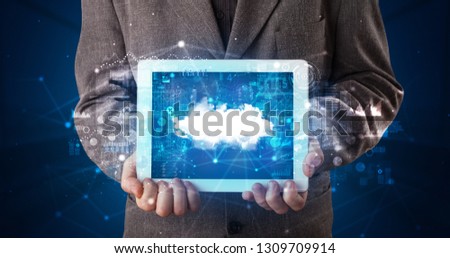 Hand holding tablet with cloud technology and dark concept