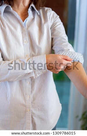 Woman is rolling up sleeves of her blouse Royalty-Free Stock Photo #1309786015