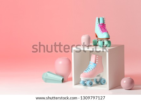 Composition with vintage roller skates and storage cube on color background. Space for text