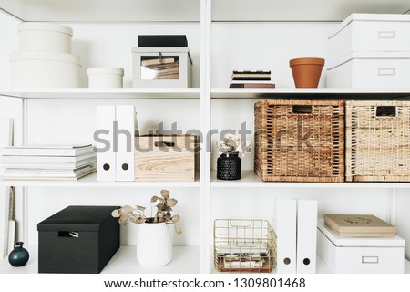 Modern home office cabinet interior design concept. White storage shelves rack with boxes, eucalyptus, decorations. Royalty-Free Stock Photo #1309801468