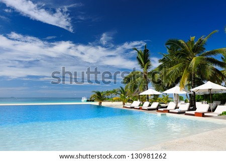 Luxury swimming pool in the tropical hotel Royalty-Free Stock Photo #130981262