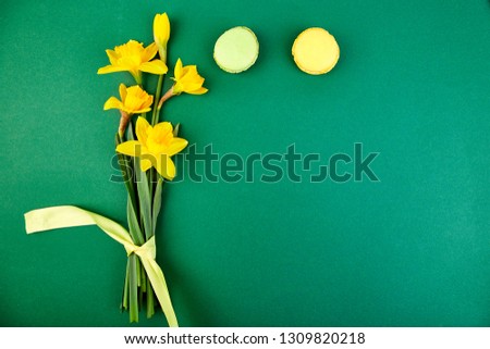 French delicacy, macaroons colorful with spring blossom. Bouquet flowers narcissus and sweets or cake macarons. Good morning. Woman or mother Day. Greeting card. Spring is coming. Cope space.