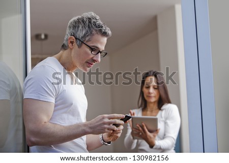 Man text messaging with his wife using a digital tablet