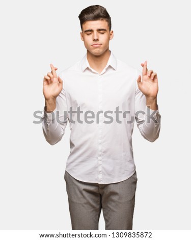 Young business cool man crossing fingers for having luck