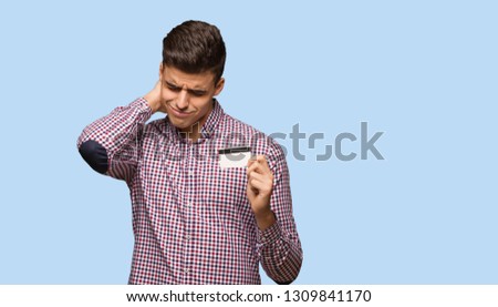 Young man holding credit card suffering neck pain