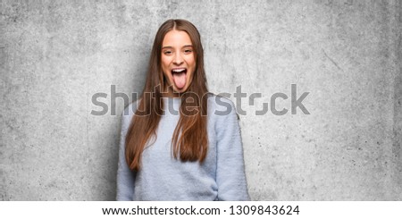 Young caucasian woman funnny and friendly showing tongue
