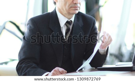 Mature businessman looking at laptop screen on workplace in the office
