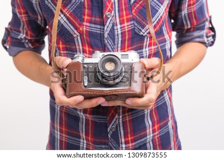 Vintage, photographer and hobby concept - close up of retro camera in man's hands over the white background