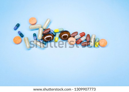 Different pills on a blue background. A photo of different medical drugs, tablets and pills on blue background Pretty pills.