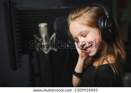 little happy girl singing in recording studio