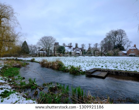 Spring snow scene of St Andrew's Church in Meonstoke in the Meon Valley near the South Downs, Hampshire, UK