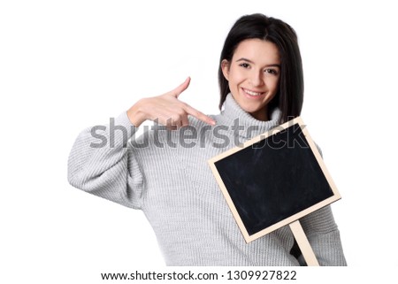 Smiling woman wearing dress holding advertising board. Isolated portrait.