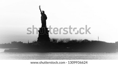 Backlight panoramic view of American symbol Statue of Liberty silhouette in New York, USA. High key black and white image.