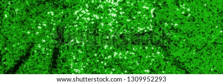 Decorative green cloth banner. Metal glitter green cloth background, close up. Trendy Metallic fabric texture. Glittering sequins, sparkling sequined textile. Metallic shimmers green fabric