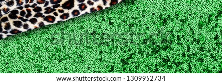 Decorative cloth banner background. Leopard pattern on faux fur and sparkling sequined textile glitter fabric. Clashing trendy background with  animal print cloth and metal texture green fabric, copy 