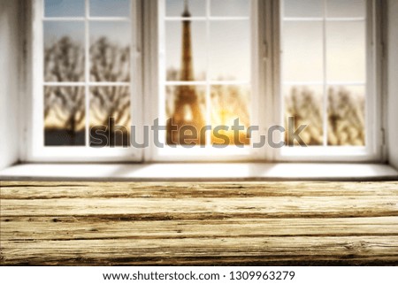 Table background of free space for your decoration. White wooden window background. Sunset time and Paris city landscape. 
