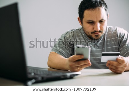 Cropped picture of man with credit card white pattern and phone