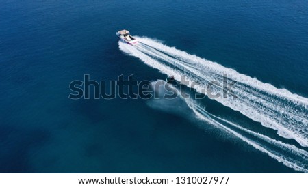 Aerial drone photo of fit man practising water ski powered by watercraft in exotic open ocean deep blue sea