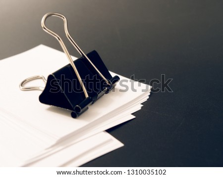 stationery metal clip for paper on a black background