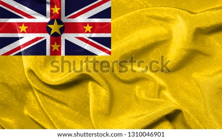 Realistic flag of Niue on the wavy surface of fabric