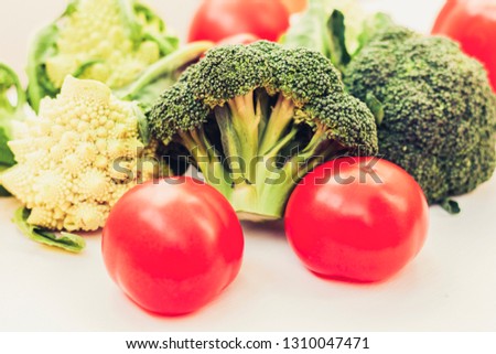 Ripe vegetables tomatoes romanesco broccoli on white wooden background with copy space for your text.