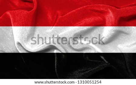 Realistic flag of Yemen on the wavy surface of fabric