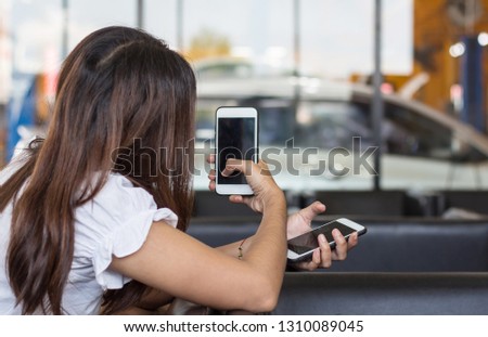Woman resting at  shop car and using smart phone photo.