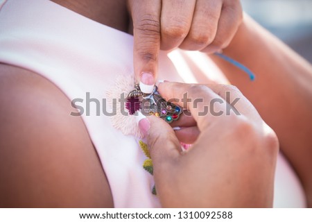 black woman attaching a broach to a pink dress  Royalty-Free Stock Photo #1310092588