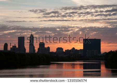 Downtown Indianapolis, Indiana, USA. Sunrise behind skyscrapers. Beautiful City Silhouette and little reflections on White River. 