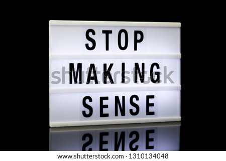 stop making sense, phrase written on lightbox reflected on black background, 