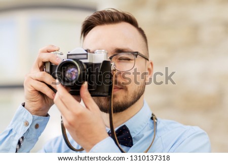 photography, technology and lifestyle - young photographer or hipster man with vintage film camera outdoors