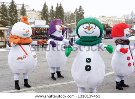 snowmen dance on a festive area near the carousel where they spend the winter holidays, the theme of holidays and entertainment