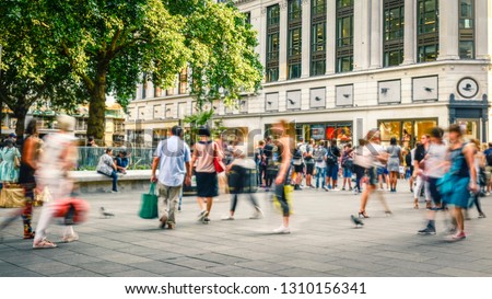 City street with motion blurred crowds of people Royalty-Free Stock Photo #1310156341