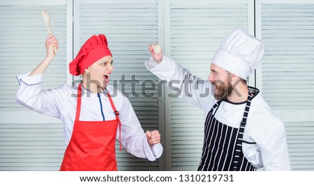 Who cook better. Culinary battle concept. Woman and bearded man culinary show competitors. Ultimate cooking challenge. Culinary battle of two chefs. Kitchen rules. Couple compete in culinary arts.