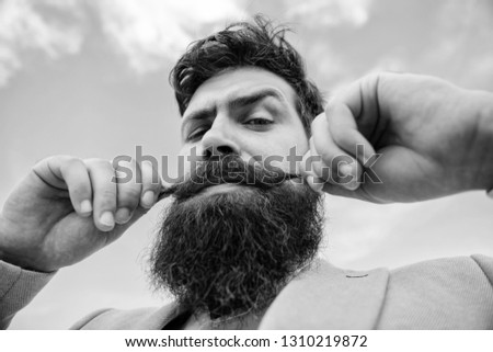 Expert tips for growing and maintaining moustache. Man bearded hipster twisting mustache sky background. Ultimate moustache grooming guide. Hipster handsome attractive guy close up.