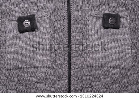 background texture gray knitted jacket with pockets and zipper close-up