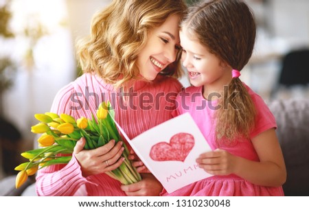 happy mother's day! child daughter congratulates mother and gives a bouquet of flowers to tulips and postcard
