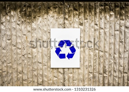 Blue Recycle Symbol Sign on a Concrete Wall.